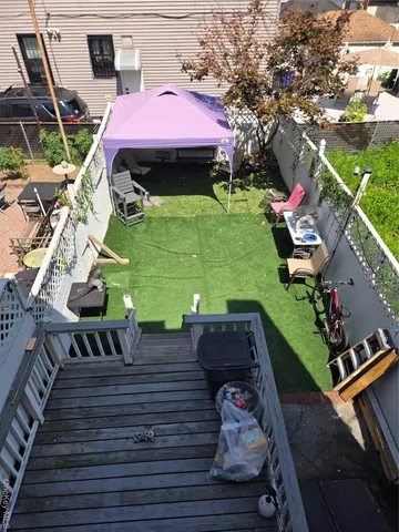 a view of a patio with table and chairs with wooden floor and fence