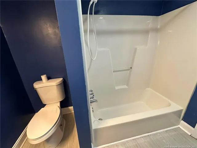 a white toilet sitting next to a bathtub