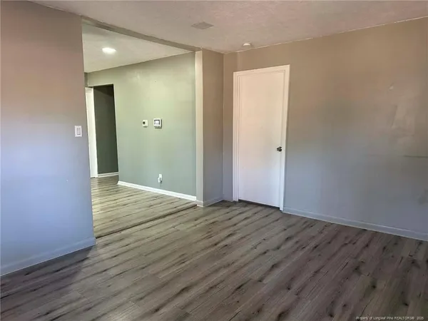 a view of an empty room with wooden floor