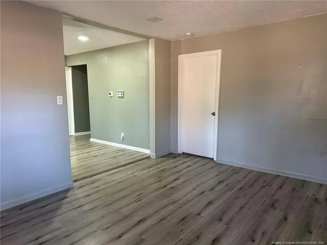 a view of an empty room with wooden floor