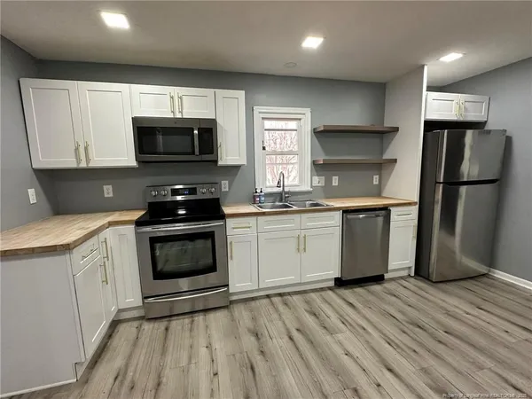 a kitchen with a stove a sink and a microwave