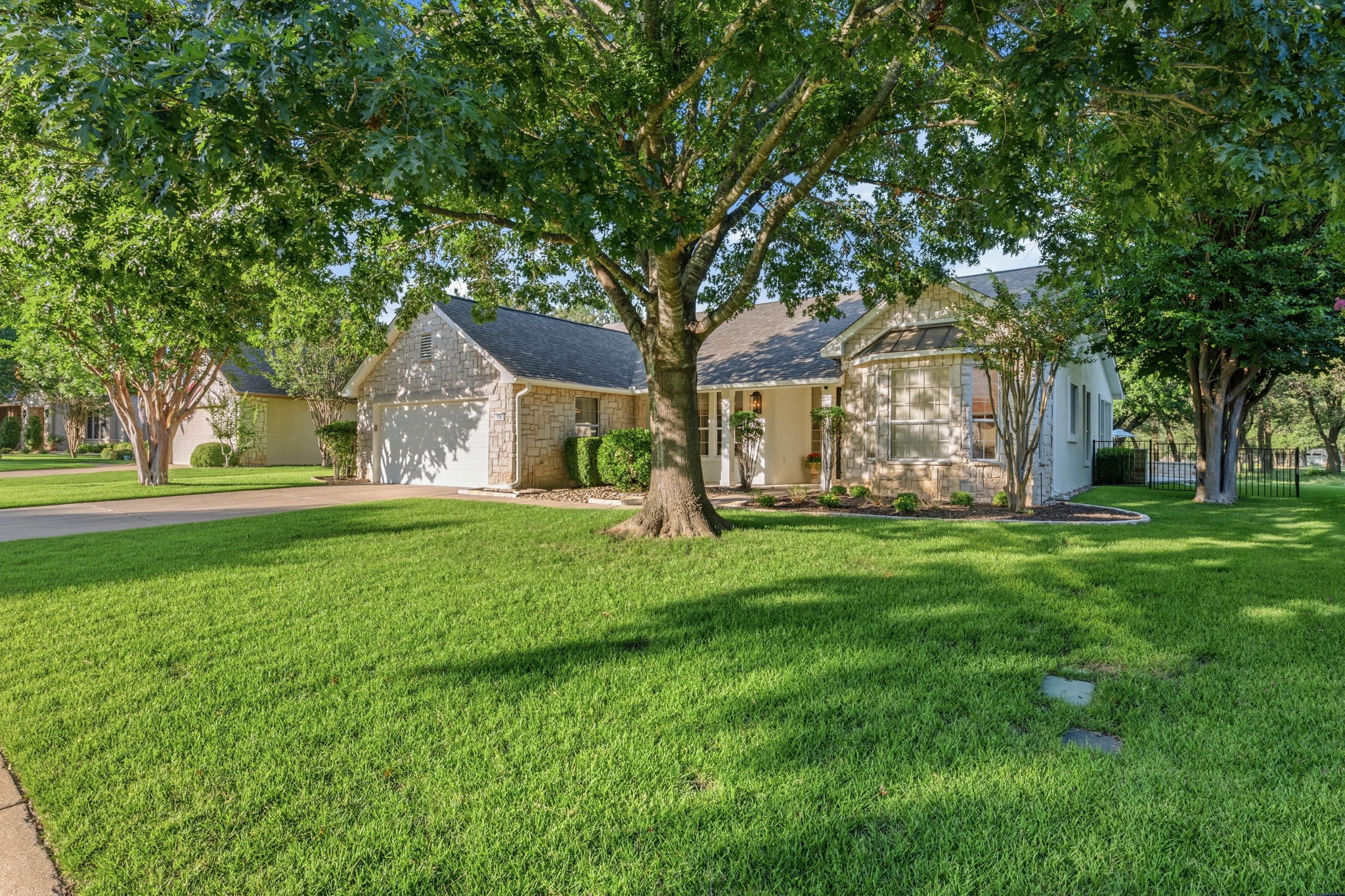 118 Cold Springs Drive Georgetown, TX 78633 - Photo 40 of 40 A well-kept lawn frames this charming home featuring a blend of stone and siding under mature shade trees.