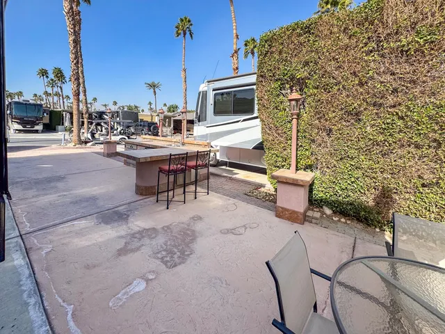 a view of a patio with table and chairs and potted plants