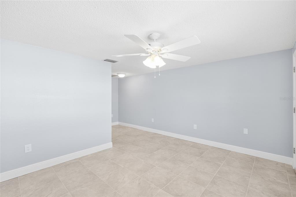 4948 Getner Street New Port Richey, FL 34652 - Photo 6 of 20 an empty room with a fan & a ceiling fan