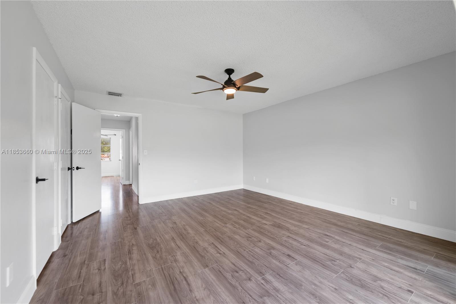 4088 Inverrary Drive, Unit 11F Lauderhill, FL 33319 - Photo 18 of 34 a view of a room with wooden floor and a ceiling fan