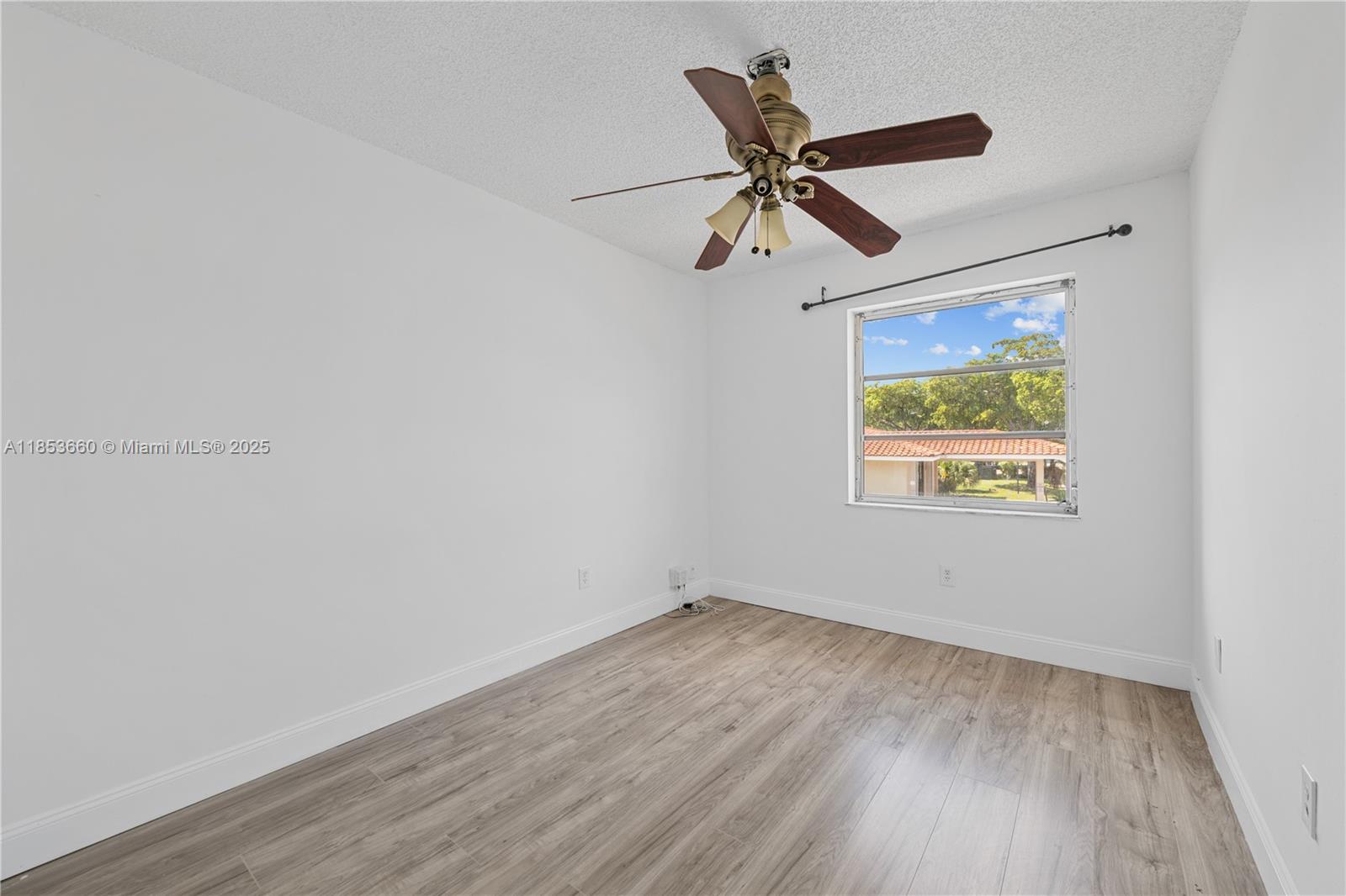 4088 Inverrary Drive, Unit 11F Lauderhill, FL 33319 - Photo 26 of 34 an empty room with wooden floor fan and windows
