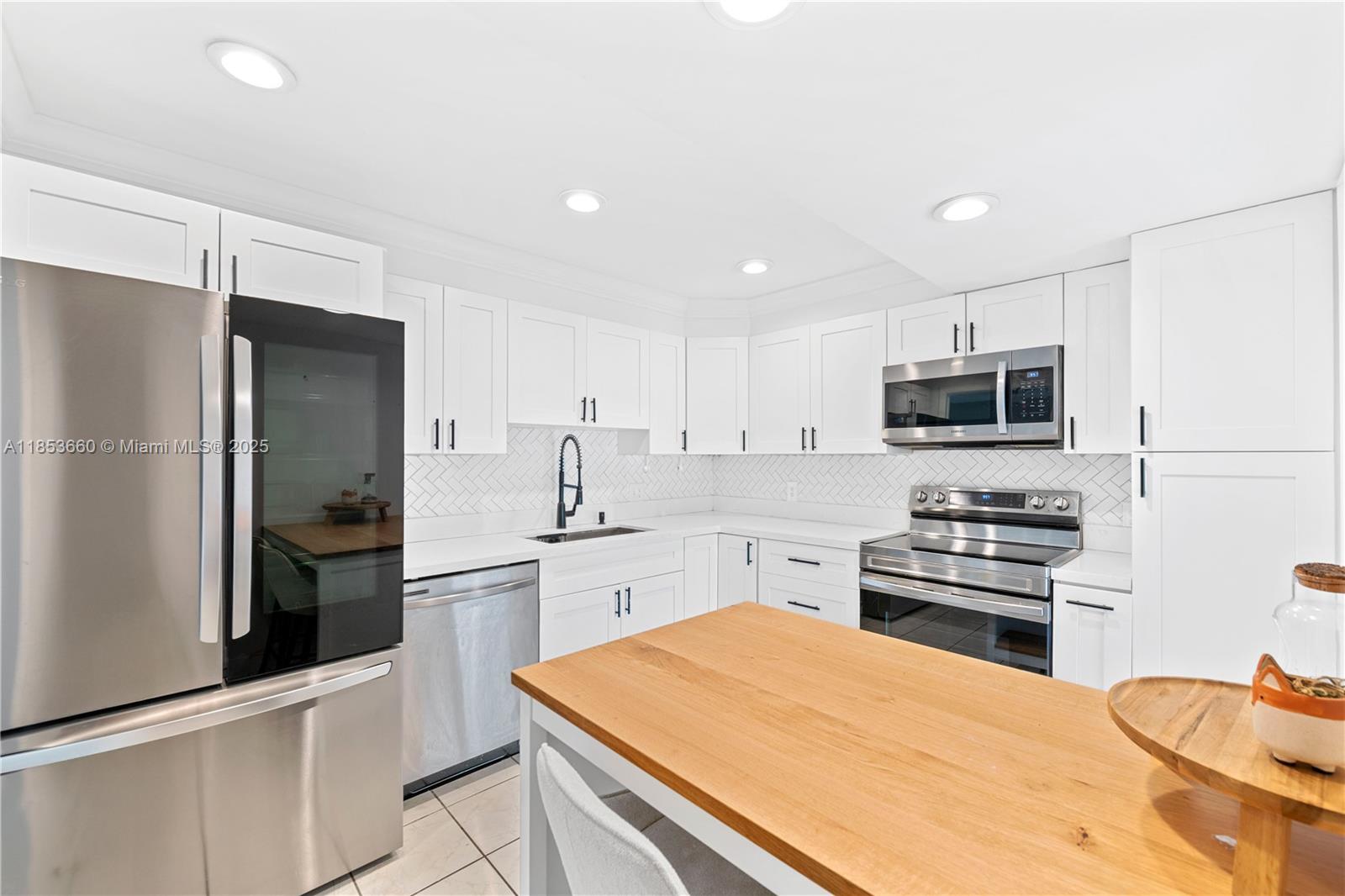 4088 Inverrary Drive, Unit 11F Lauderhill, FL 33319 - Photo 7 of 34 a kitchen with stainless steel appliances kitchen island granite countertop a refrigerator stove and sink