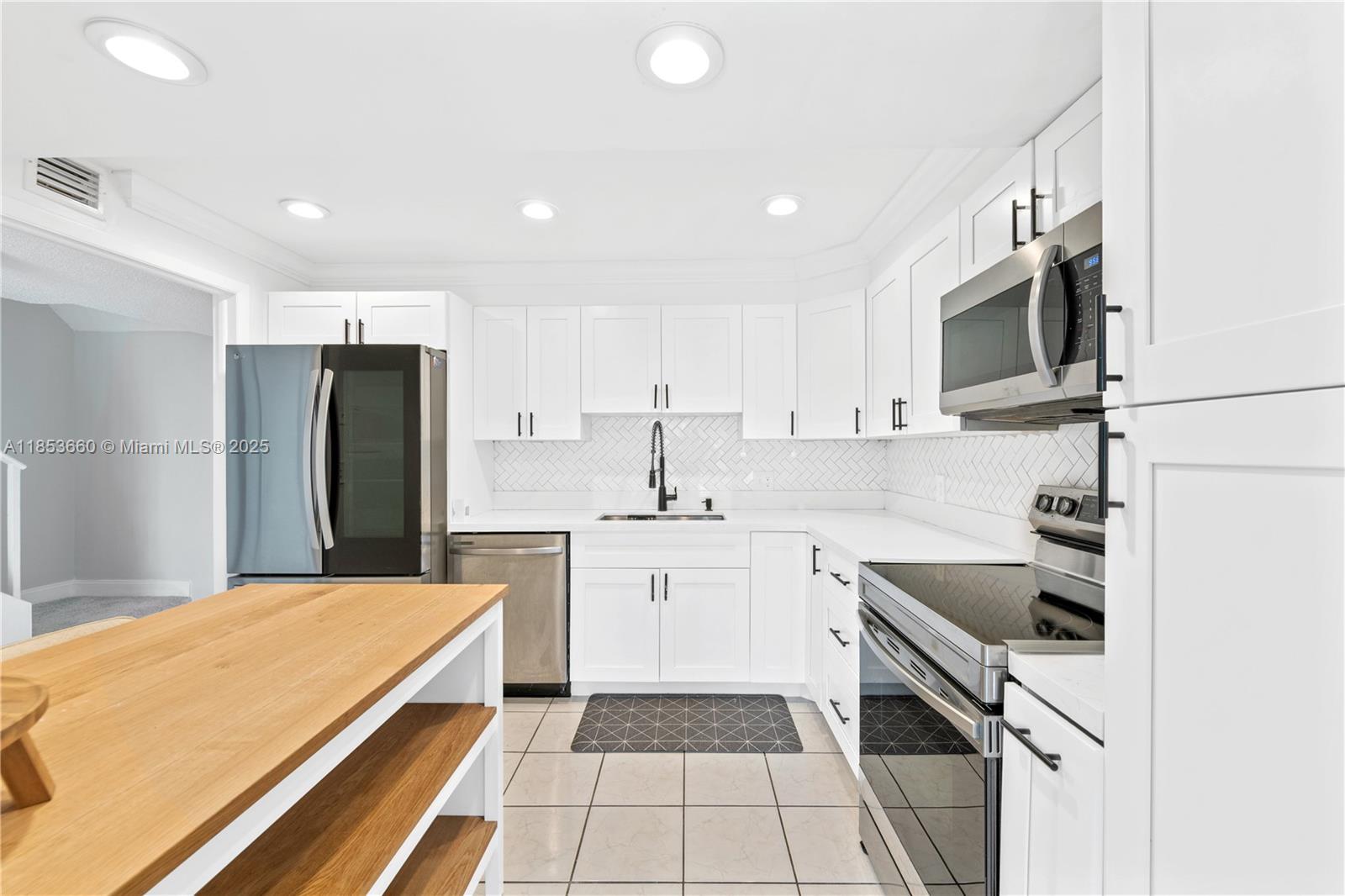 4088 Inverrary Drive, Unit 11F Lauderhill, FL 33319 - Photo 9 of 34 a kitchen with a sink stainless steel appliances and cabinets