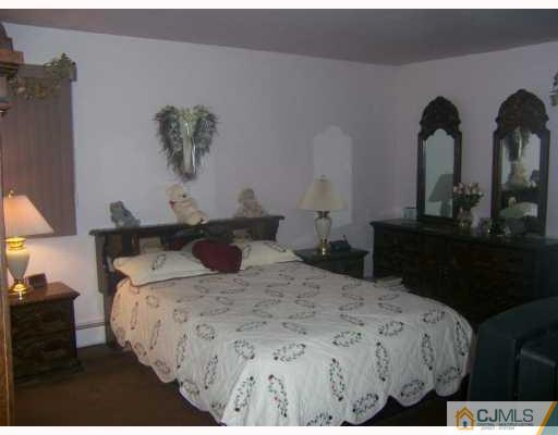 14 Library Place Edison, NJ 08820 - Photo 3 of 8 a bedroom with a bed and a potted plant on th dresser