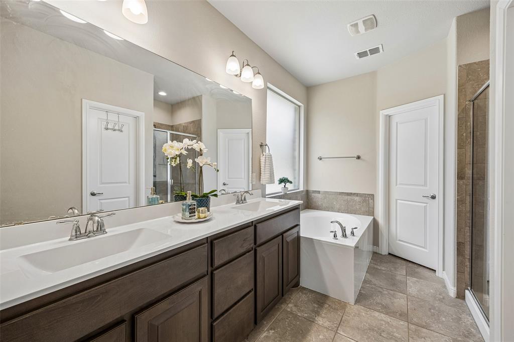 2508 Red Draw Road Fort Worth, TX 76177 - Photo 18 of 38 Dual vanity with undermount sinks, an elongated mirror, a built-in bathtub, and a separate glass-enclosed shower