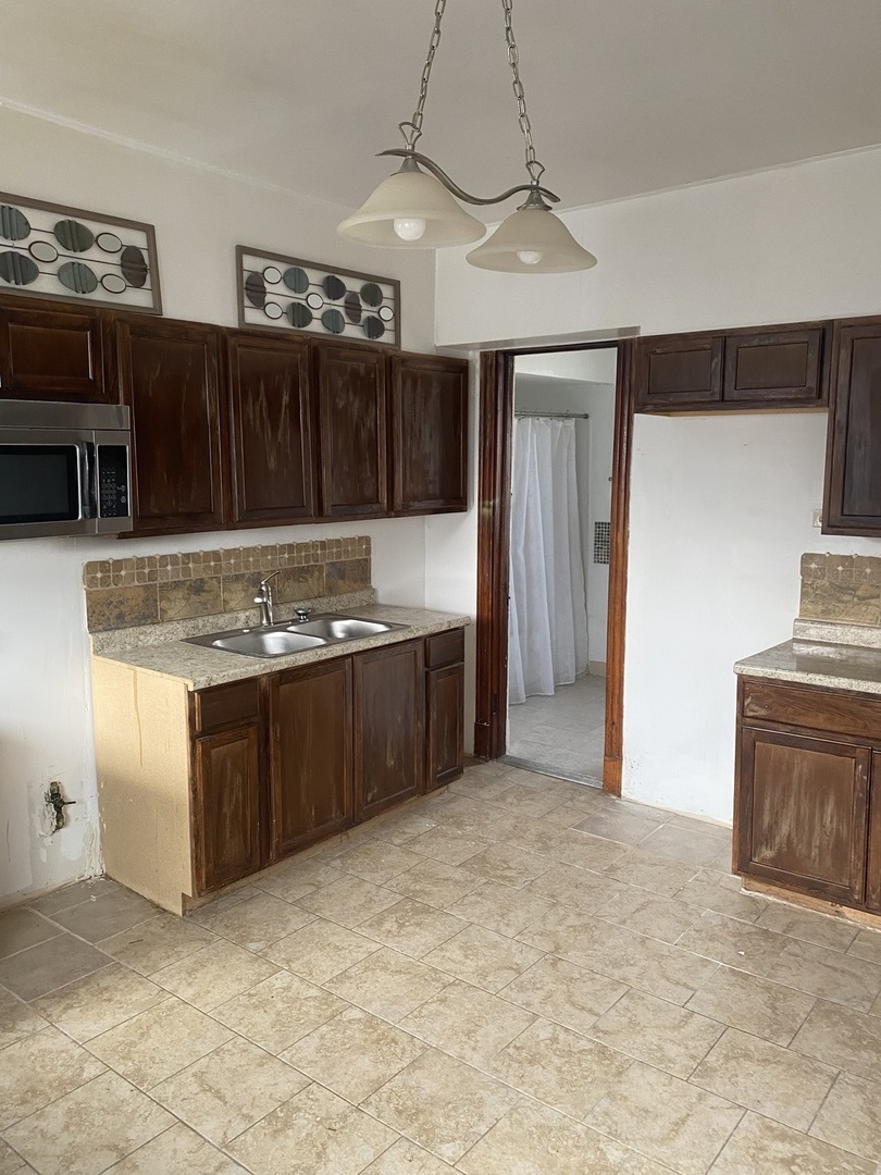 6549 South Bishop Street Chicago, IL 60636 - Photo 18 of 18 a kitchen with stainless steel appliances granite countertop a stove a sink and a microwave