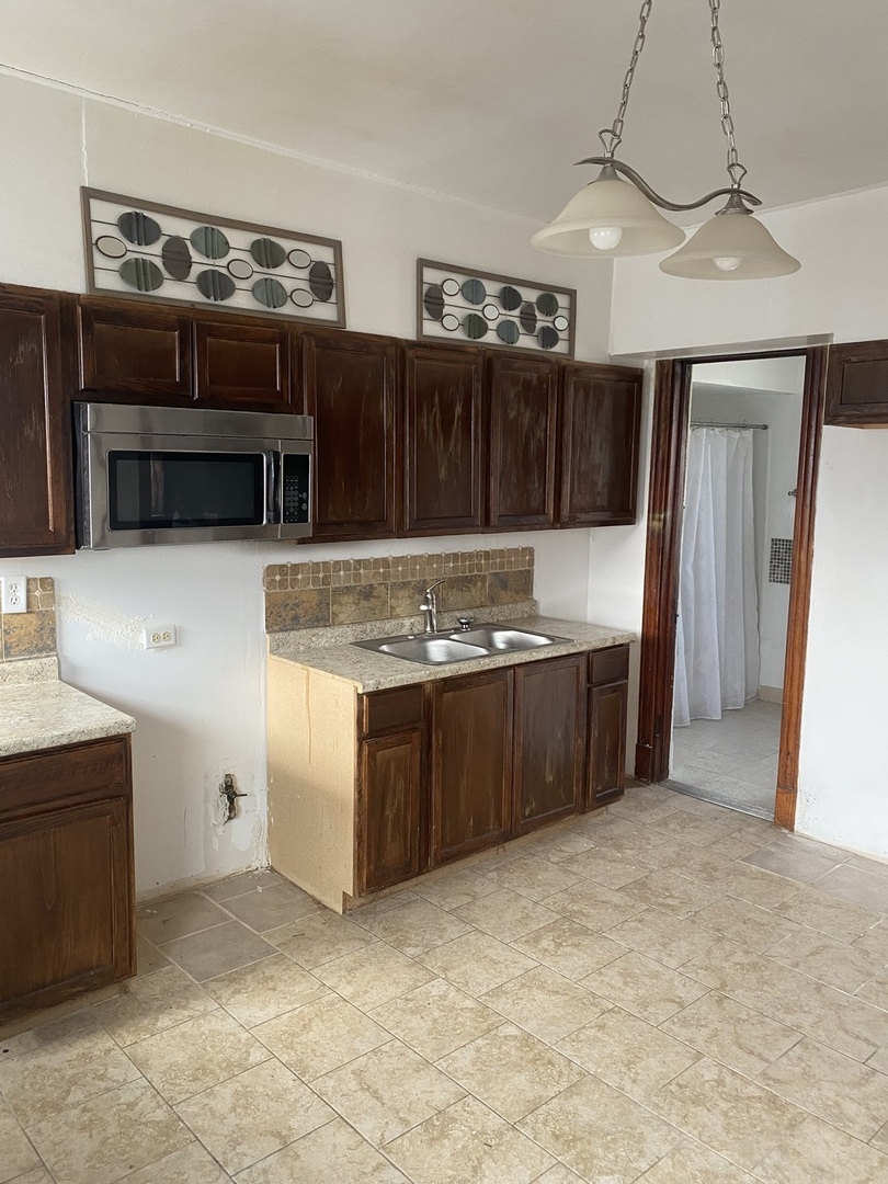 6549 South Bishop Street Chicago, IL 60636 - Photo 7 of 18 a kitchen with stainless steel appliances granite countertop a stove a sink and a refrigerator