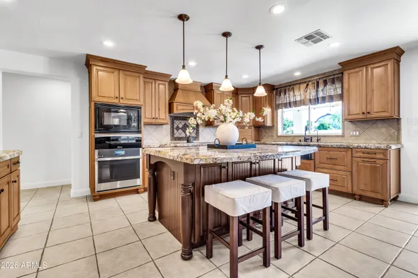 a kitchen with granite countertop a stove and cabinets