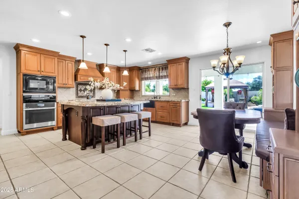 a dining room with furniture a chandelier and wooden floor