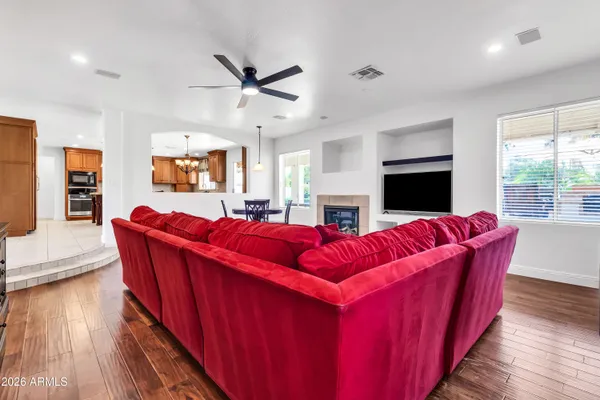 a spacious bedroom with a bed a dresser and a chandelier