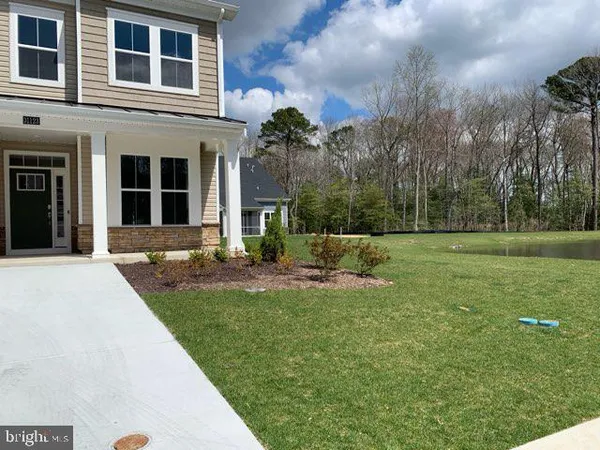 a front view of a house with a yard and trees
