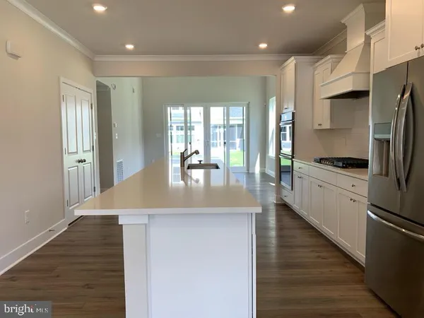 a kitchen with stainless steel appliances granite countertop a refrigerator a stove and a wooden floors