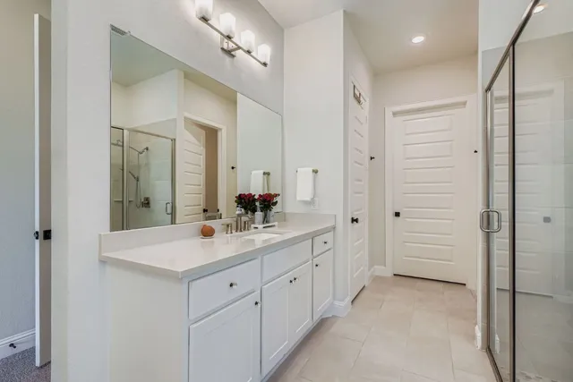 a spacious bathroom with a shower sink and mirror