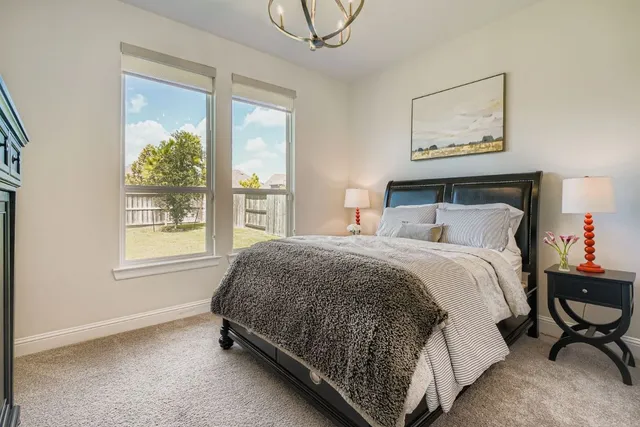 a bedroom with a bed lamp and a window