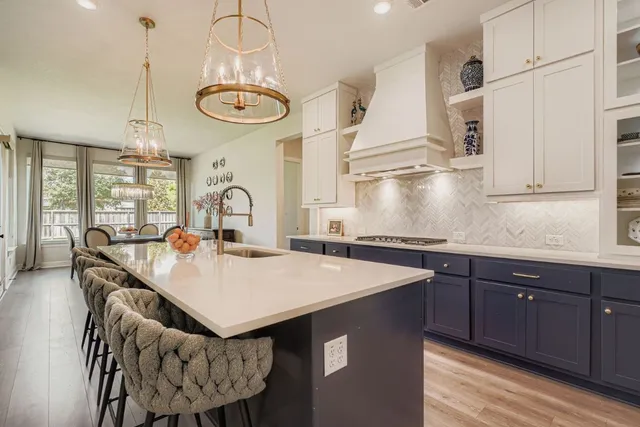 a kitchen with a table chairs and white cabinets