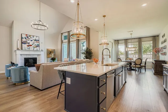 a open kitchen with sink stove and white cabinets with wooden floor