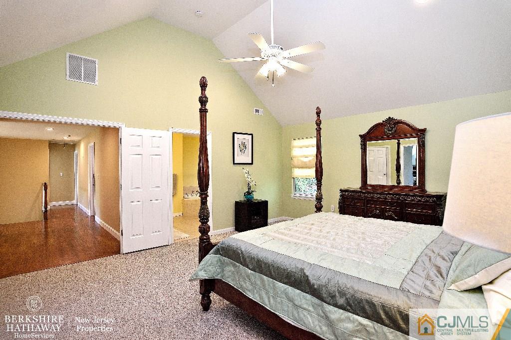40 Edgewood Road Edison, NJ 08820 - Photo 16 of 25 a bedroom with a large bed and a chandelier