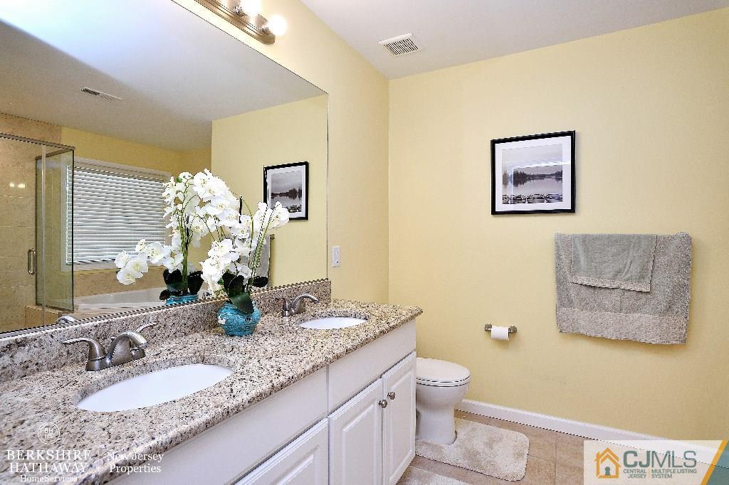 40 Edgewood Road Edison, NJ 08820 - Photo 18 of 25 a bathroom with a granite countertop toilet a sink and a mirror