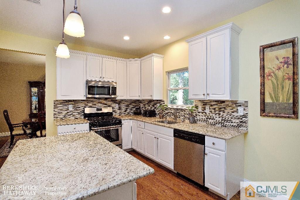 40 Edgewood Road Edison, NJ 08820 - Photo 9 of 25 a kitchen with stainless steel appliances granite countertop a stove top oven a sink dishwasher and a refrigerator with wooden floor