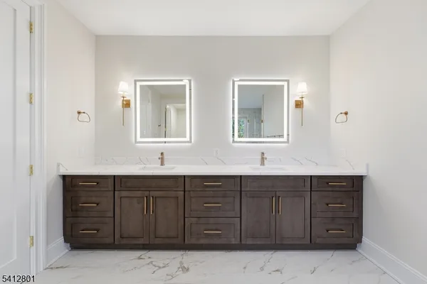a bathroom with a granite countertop double vanity sink and mirror