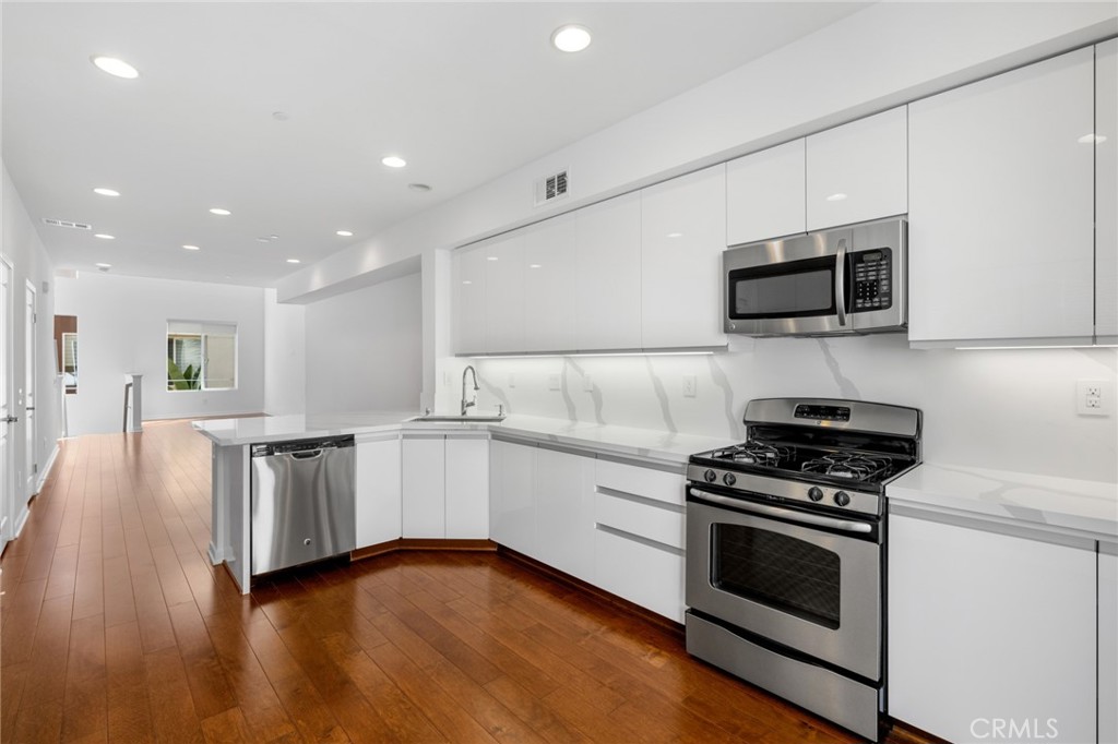 a kitchen with granite countertop a stove top oven and cabinets
