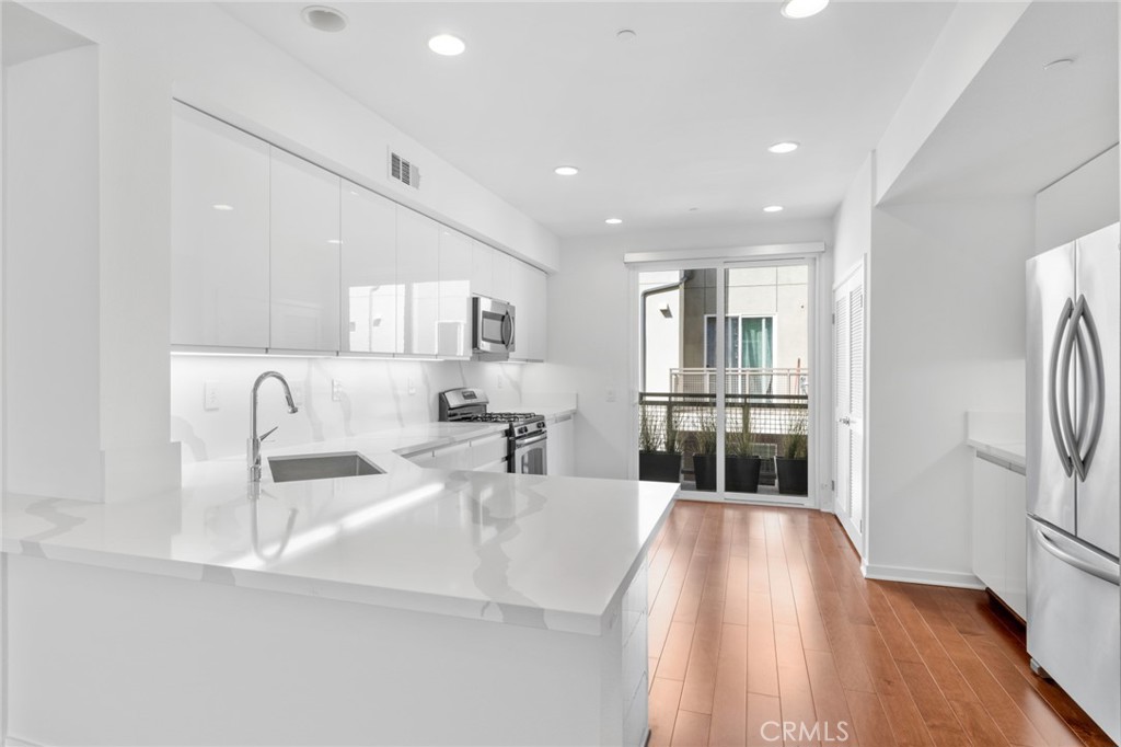 561 Rockefeller Irvine, CA 92612 - Photo 2 of 26 a kitchen with stainless steel appliances granite countertop a refrigerator and a sink