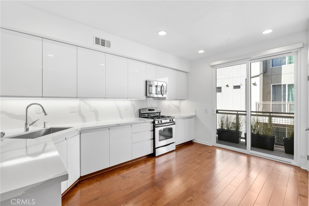 561 Rockefeller Irvine, CA 92612 - Photo 3 of 26 a kitchen with stainless steel appliances granite countertop a refrigerator and a sink