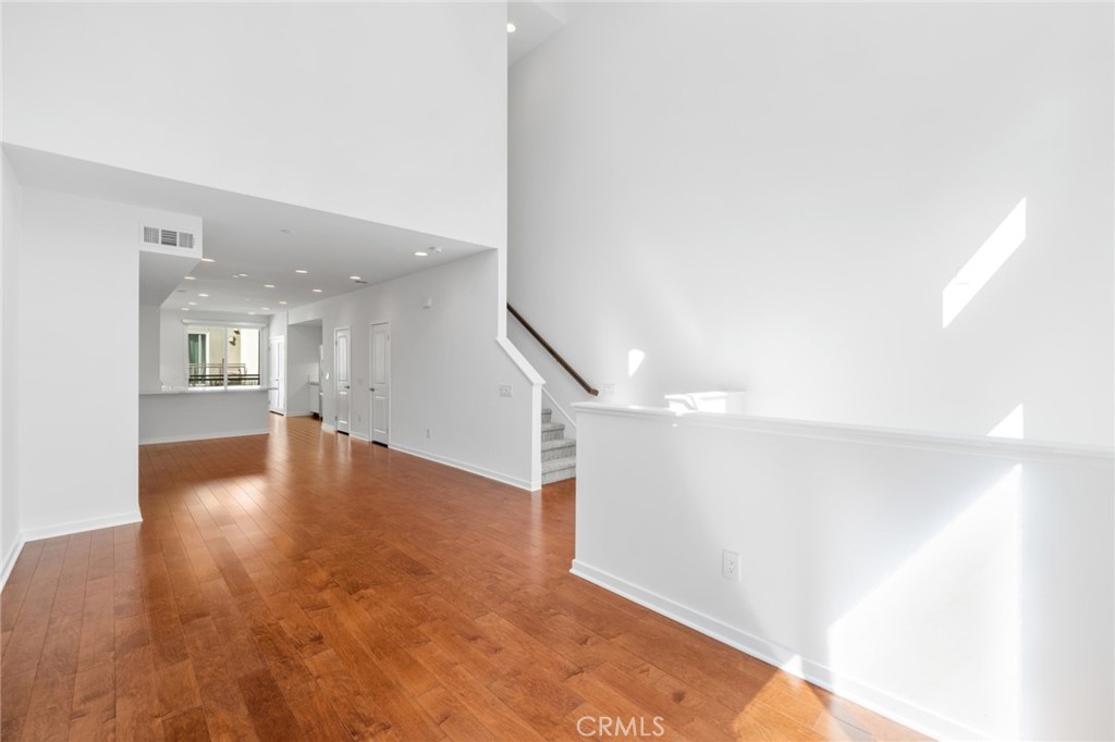 561 Rockefeller Irvine, CA 92612 - Photo 6 of 26 a view of a hallway with wooden floor and a living room