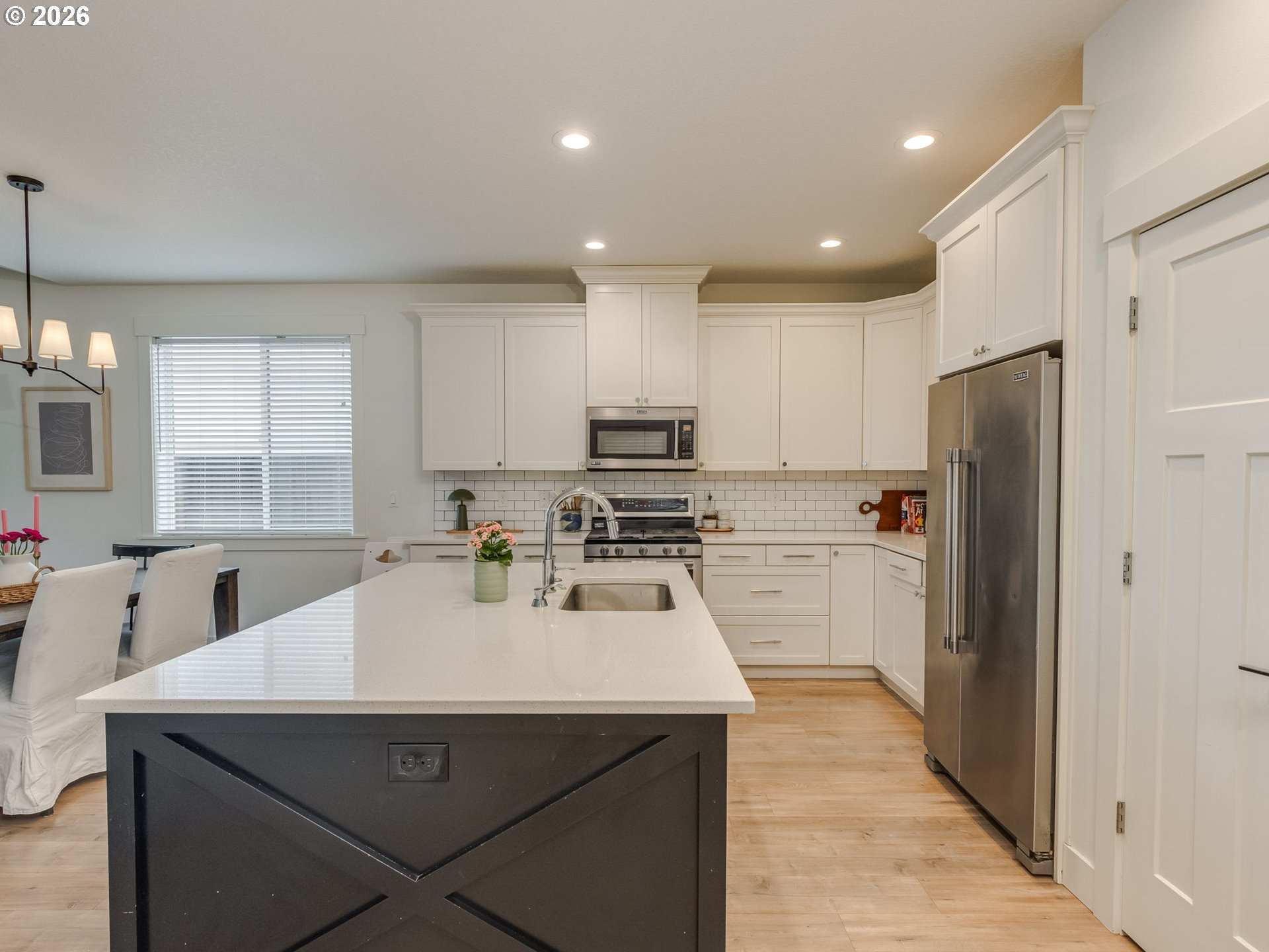 2893 4th Street Hubbard, OR 97032 - Photo 39 of 41 a kitchen with a sink a kitchen island stainless steel appliances cabinets and a window