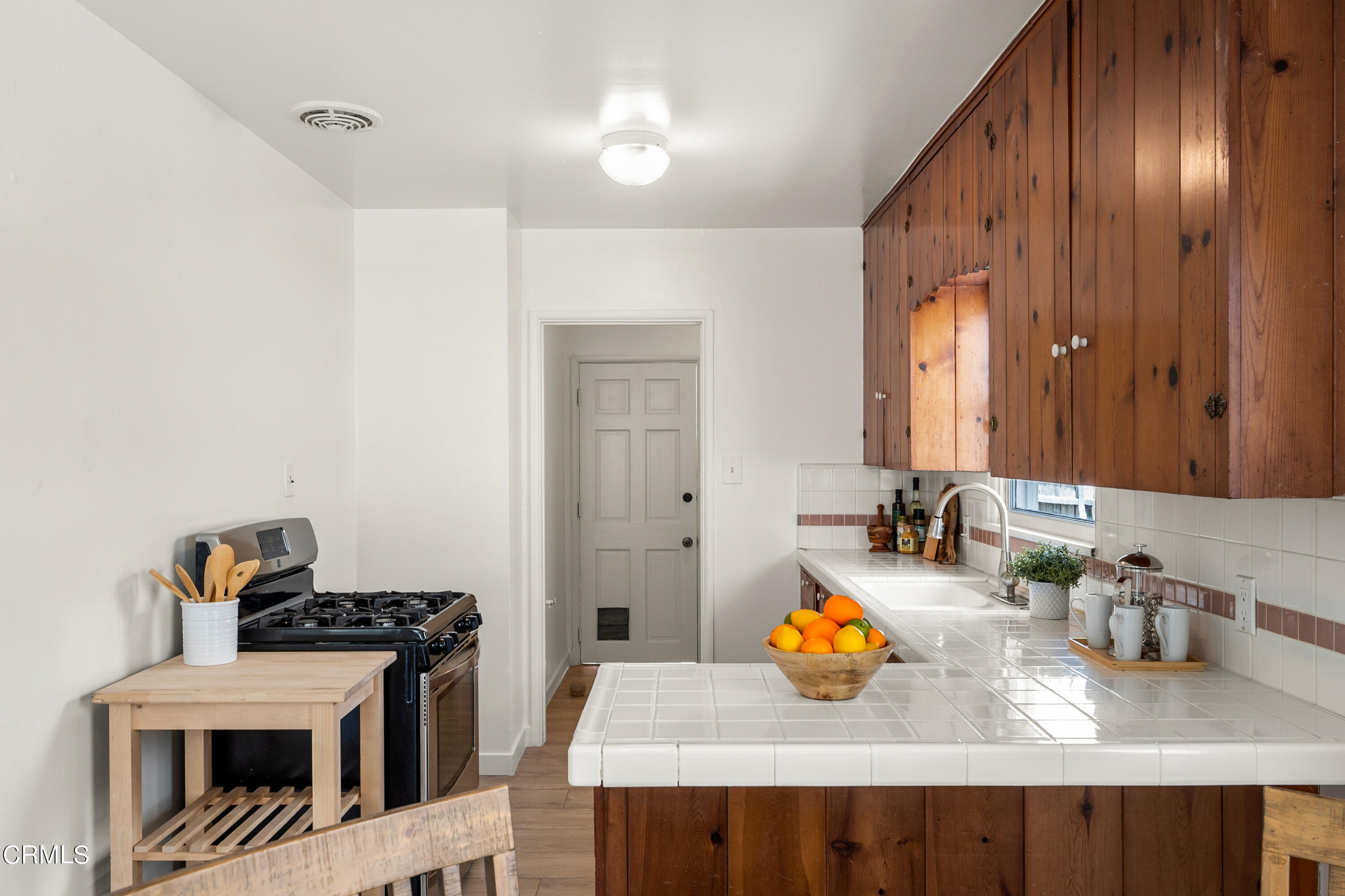 3652 Ocean Drive Oxnard, CA 93035 - Photo 11 of 28 a kitchen with a sink a stove and wooden floor