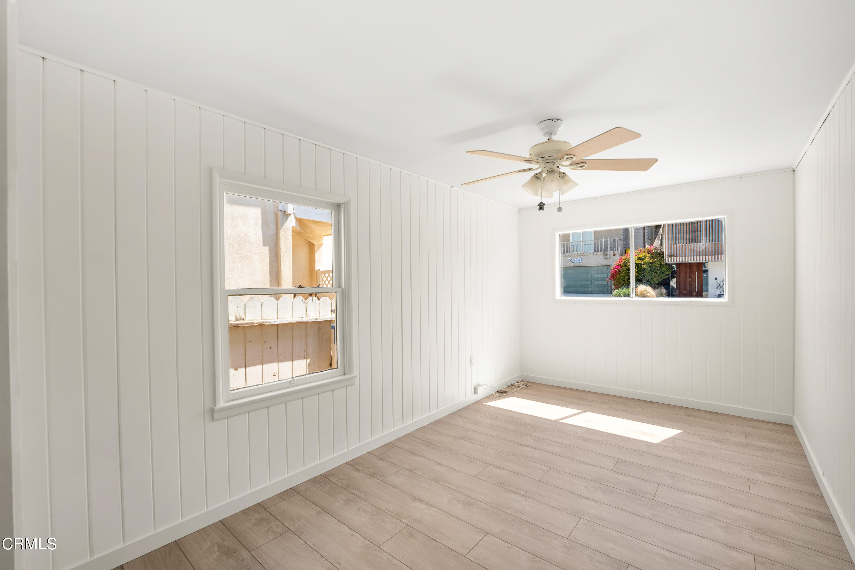 3652 Ocean Drive Oxnard, CA 93035 - Photo 16 of 28 an empty room with wooden floor chandelier fan and windows
