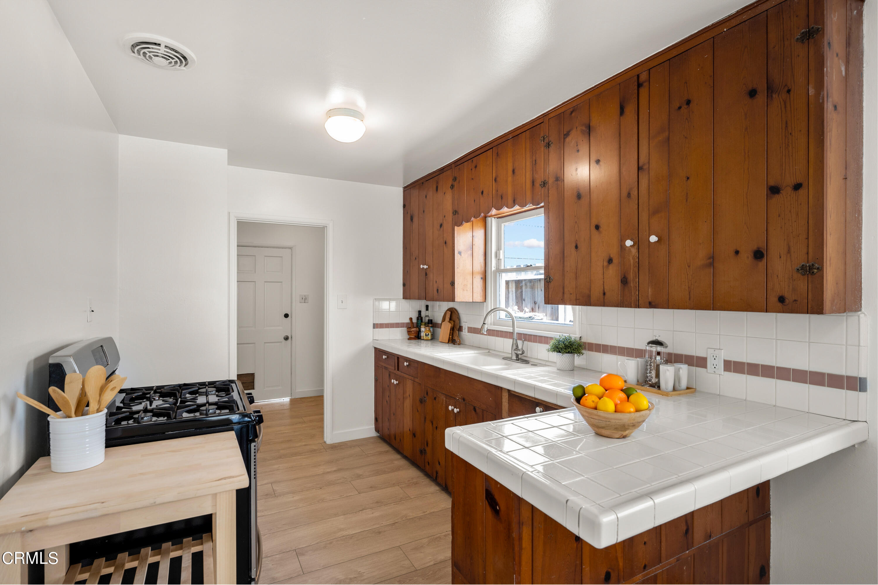 3652 Ocean Drive Oxnard, CA 93035 - Photo 10 of 28 a kitchen with a sink a stove and wooden cabinets