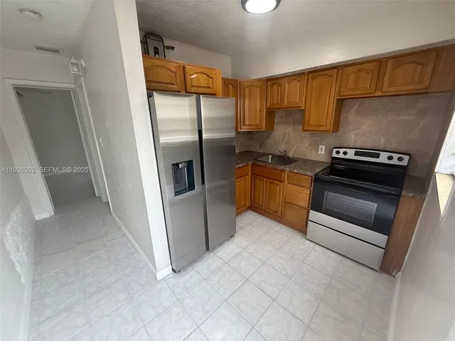 a kitchen with stainless steel appliances granite countertop a refrigerator and a stove