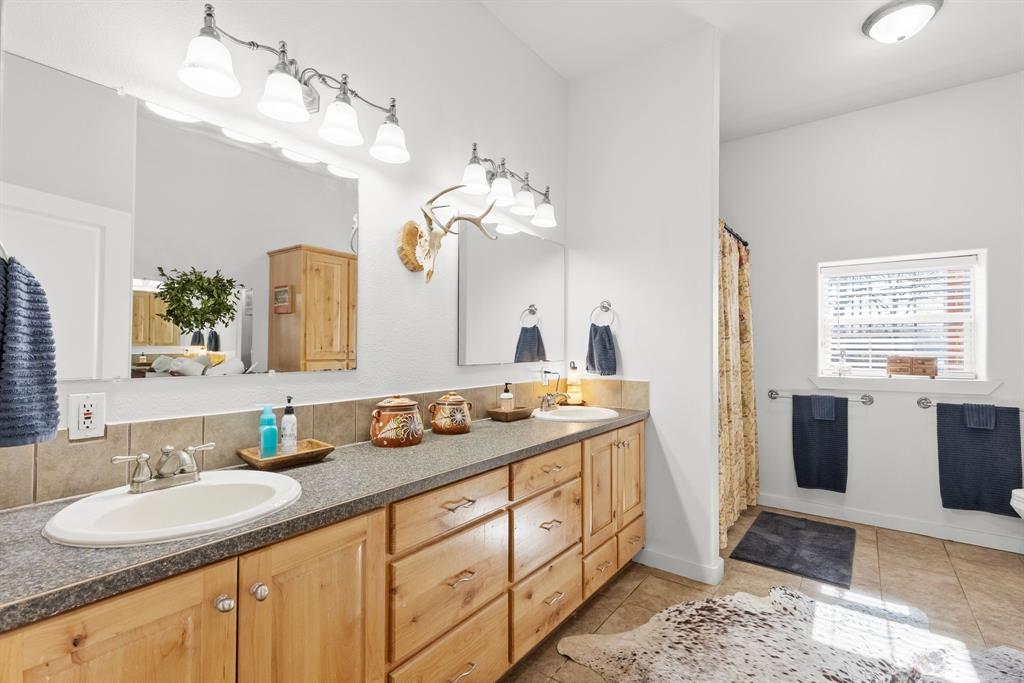24 County Rd NW 1060 Talco, TX 75487 - Photo 21 of 40 a bathroom with a granite countertop sink a large mirror and a bathtub