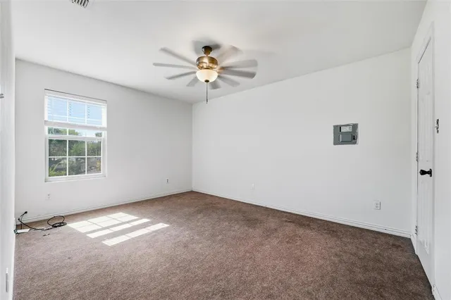 an empty room with a window and a ceiling fan