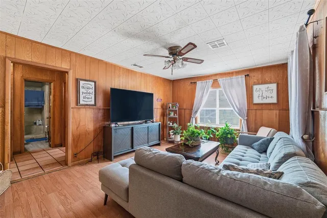 a living room with furniture a flat screen tv and a large window