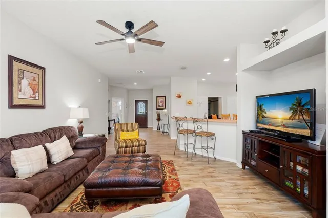 a living room with furniture and a flat screen tv with wooden floor