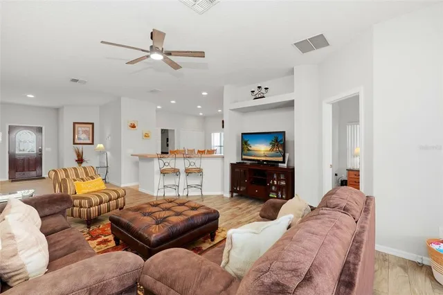 a living room with furniture kitchen view and a flat screen tv