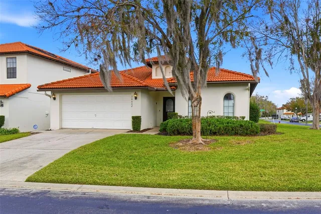 a white house that has a tree in front of it