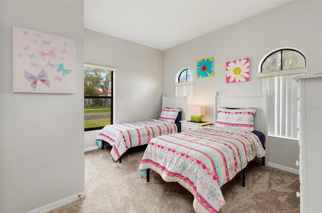 a bedroom with two beds and a painting on the wall