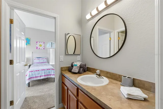 a bathroom with a granite countertop double vanity sink and a mirror
