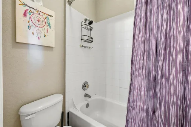 a white toilet sitting next to a shower curtain