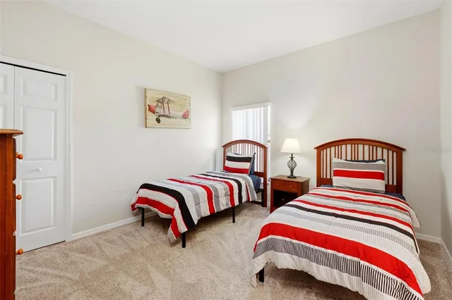 a bedroom with two beds and lamp