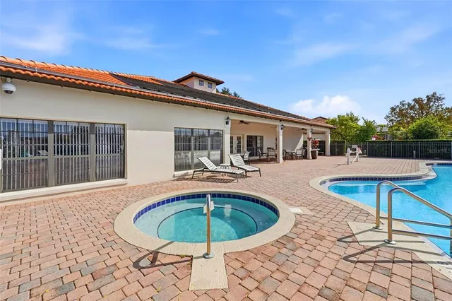 a view of house with swimming pool and a yard
