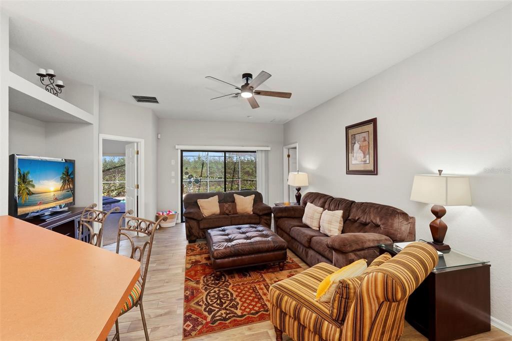 16602 Lazy Breeze Loop Clermont, FL 34714 - Photo 9 of 51 a living room with furniture a ceiling fan and a flat screen tv
